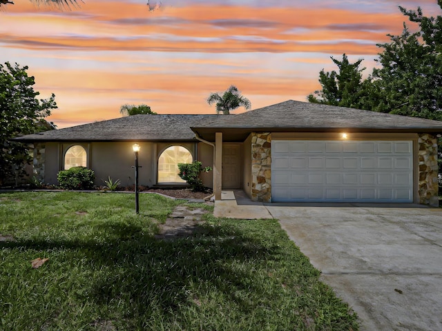 view of front of house featuring a garage and a lawn