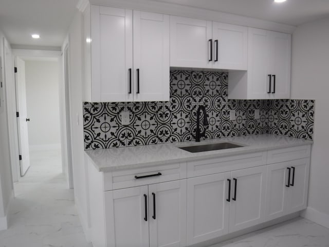 kitchen featuring white cabinetry, sink, and decorative backsplash