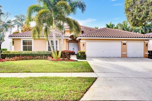 mediterranean / spanish-style house with a garage and a front lawn