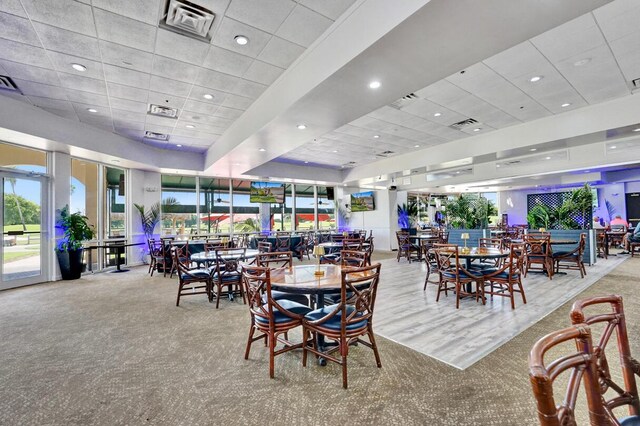 dining room featuring a drop ceiling and light colored carpet