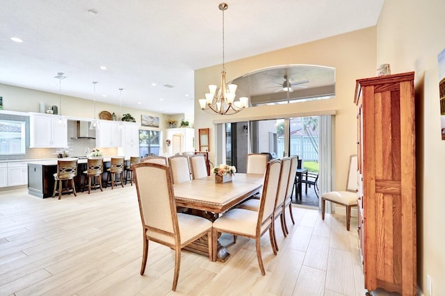 dining area with plenty of natural light, ceiling fan with notable chandelier, and light hardwood / wood-style flooring