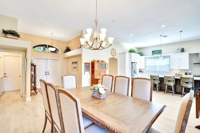 dining space featuring light hardwood / wood-style floors and a chandelier