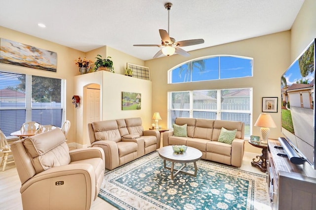 living room featuring plenty of natural light, a textured ceiling, and ceiling fan