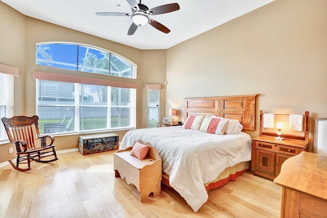 bedroom with multiple windows, ceiling fan, and light wood-type flooring