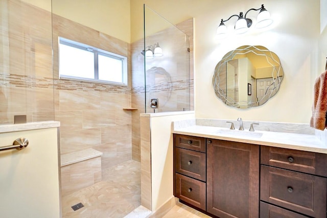 bathroom with vanity and a tile shower