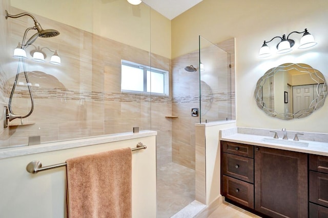 bathroom featuring a tile shower and vanity