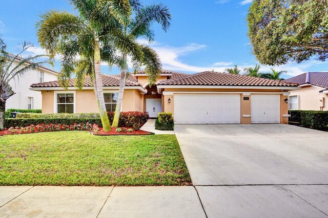 mediterranean / spanish home with a garage and a front yard