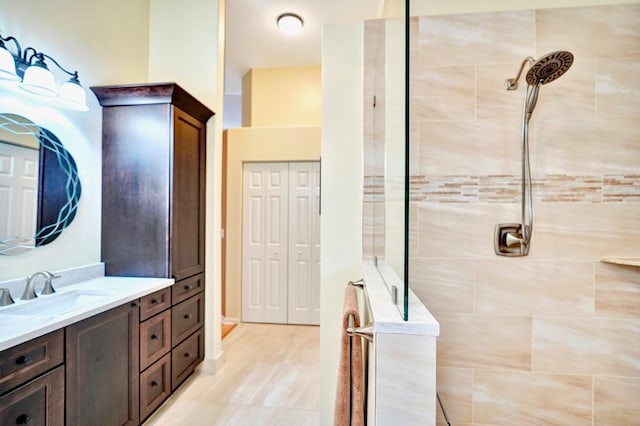 bathroom with vanity and a tile shower