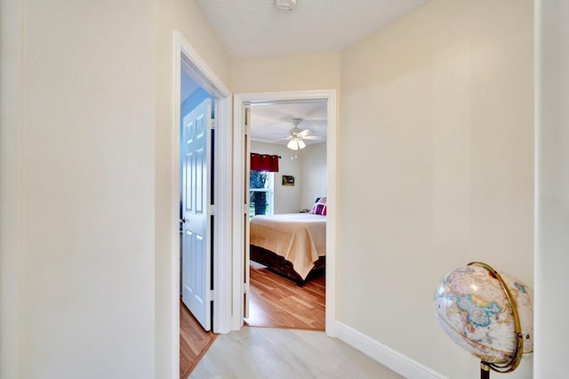 corridor featuring a textured ceiling and light wood-type flooring