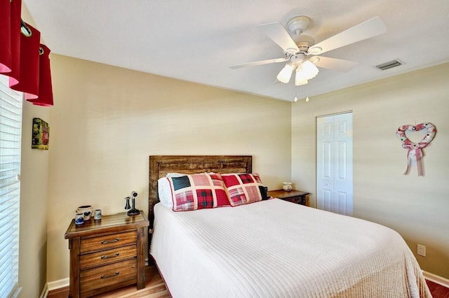 bedroom with hardwood / wood-style flooring, ceiling fan, and a closet