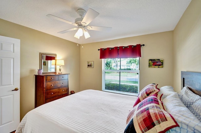 bedroom with a textured ceiling and ceiling fan