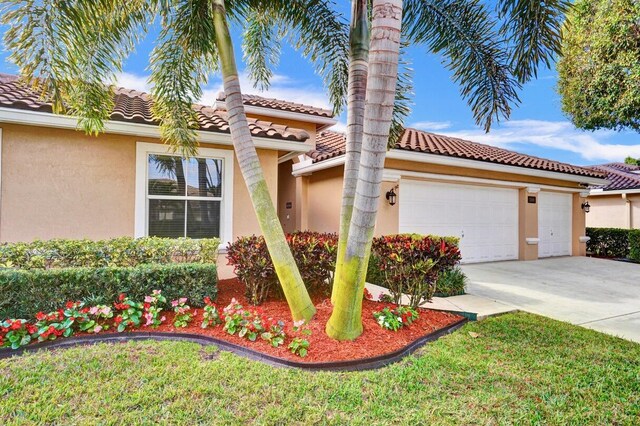 mediterranean / spanish house with a garage and a front yard