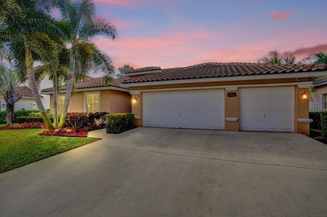 mediterranean / spanish-style home with a garage and a lawn