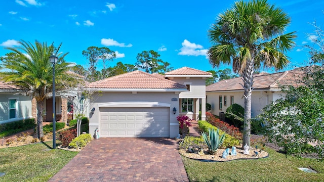 mediterranean / spanish home featuring a garage and a front lawn