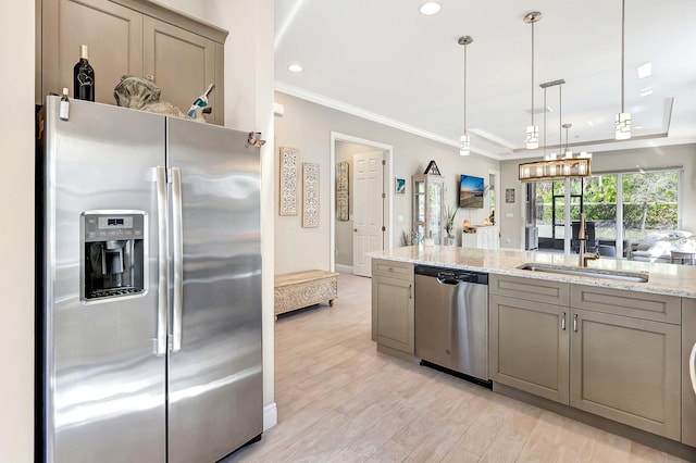 kitchen with sink, crown molding, hanging light fixtures, stainless steel appliances, and light stone countertops