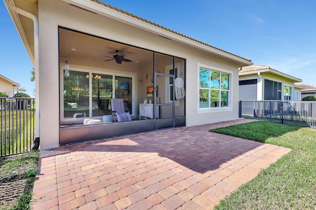 rear view of house featuring a yard, ceiling fan, and a patio area