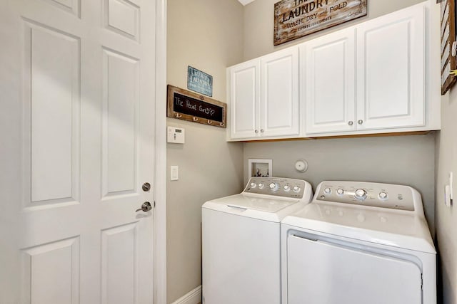 washroom with cabinets and washer and dryer