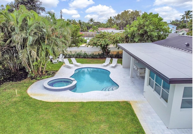 view of swimming pool featuring a yard, a patio area, and an in ground hot tub