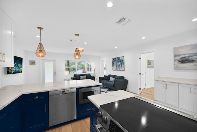 kitchen with pendant lighting, stainless steel appliances, blue cabinets, and light hardwood / wood-style floors