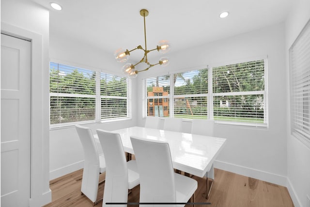 dining area with light hardwood / wood-style flooring and a chandelier