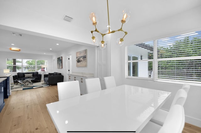 dining room with light hardwood / wood-style flooring and a chandelier