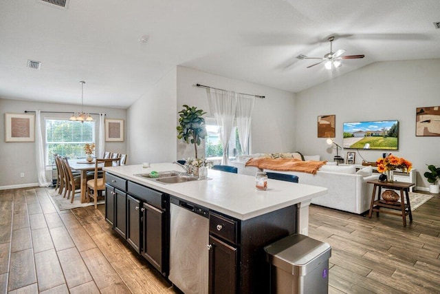 kitchen with decorative light fixtures, sink, a kitchen island with sink, stainless steel dishwasher, and light hardwood / wood-style flooring