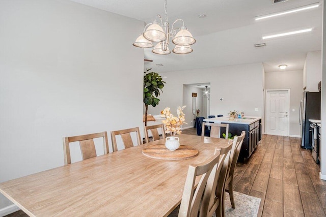 dining room with wood-type flooring and a chandelier