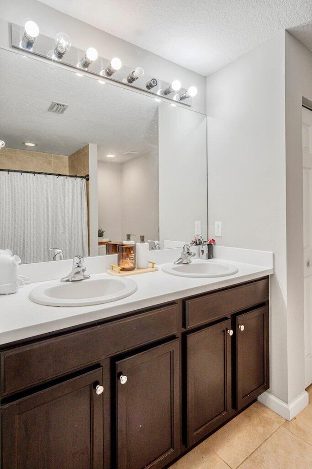 bathroom featuring tile patterned flooring, vanity, curtained shower, and a textured ceiling