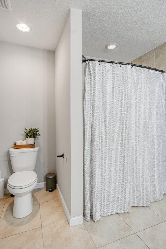 bathroom featuring tile patterned flooring, a shower with curtain, a textured ceiling, and toilet