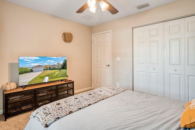 carpeted bedroom with ceiling fan and a closet