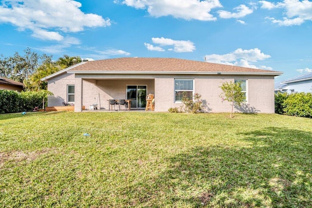 back of property with a lawn and a patio area