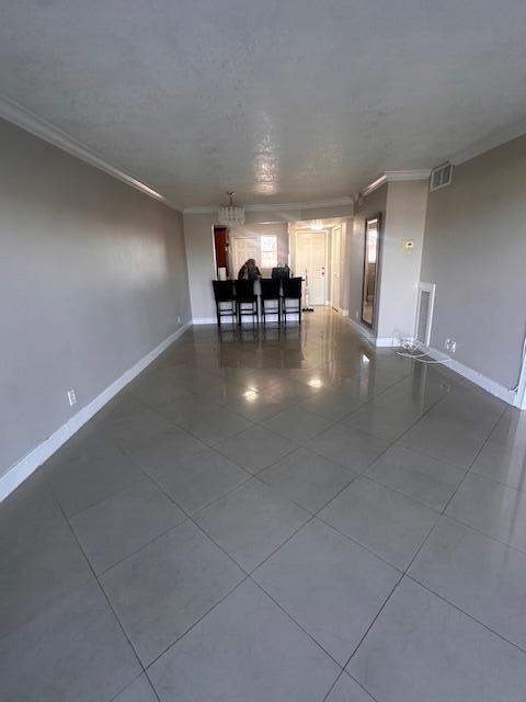 tiled spare room with ornamental molding