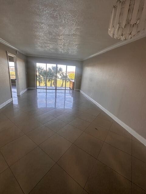 unfurnished room featuring crown molding, tile patterned floors, and a textured ceiling