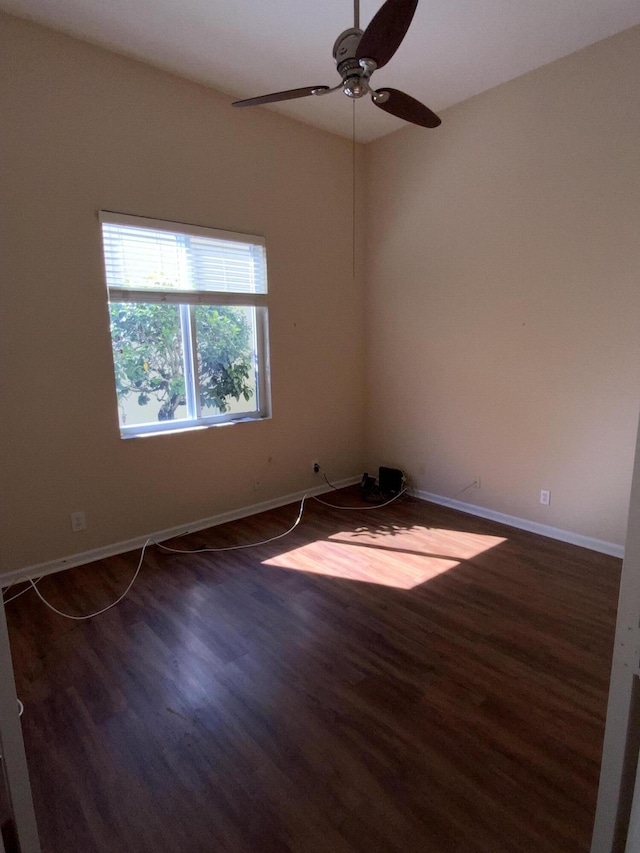 empty room with ceiling fan and dark hardwood / wood-style flooring