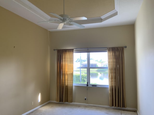 empty room featuring ceiling fan and a tray ceiling