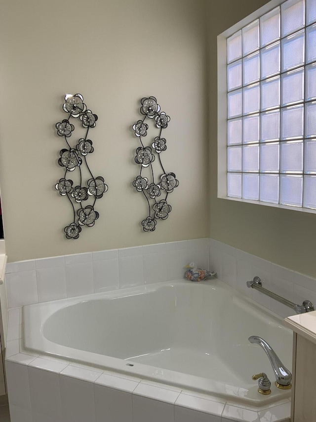 bathroom featuring tiled tub and a healthy amount of sunlight