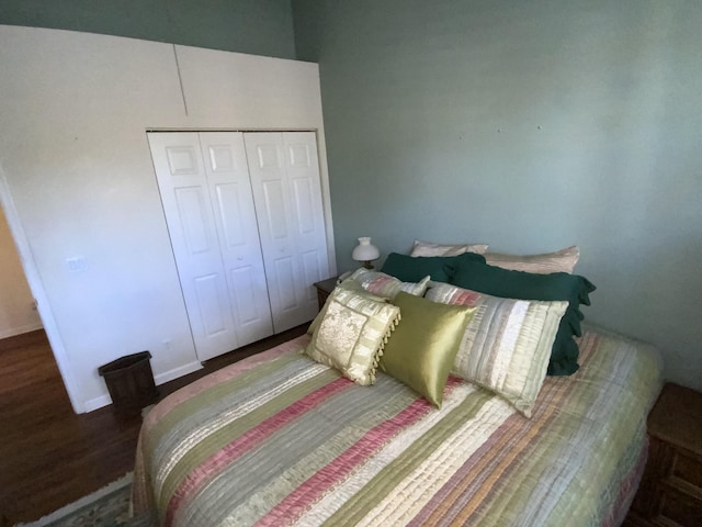 bedroom with dark hardwood / wood-style flooring and a closet