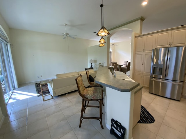 kitchen featuring stainless steel refrigerator with ice dispenser, sink, light tile patterned floors, pendant lighting, and ceiling fan