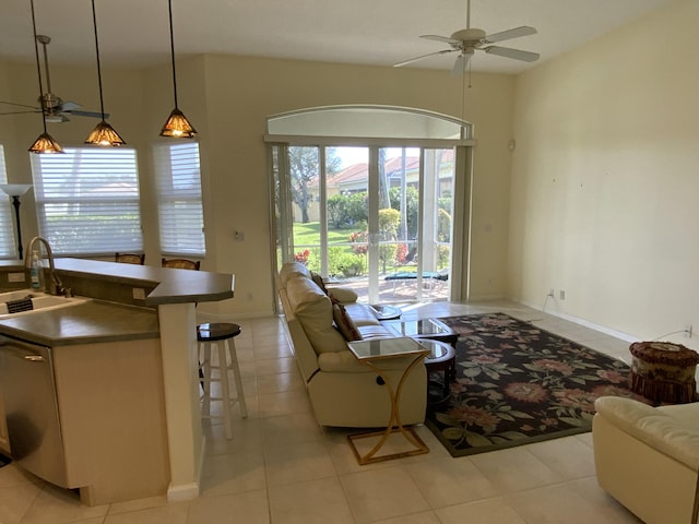 living room featuring light tile patterned flooring, sink, and ceiling fan