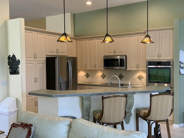 kitchen with pendant lighting, white cabinetry, appliances with stainless steel finishes, and decorative backsplash