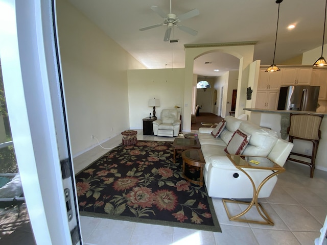 living room with light tile patterned floors, vaulted ceiling, and ceiling fan