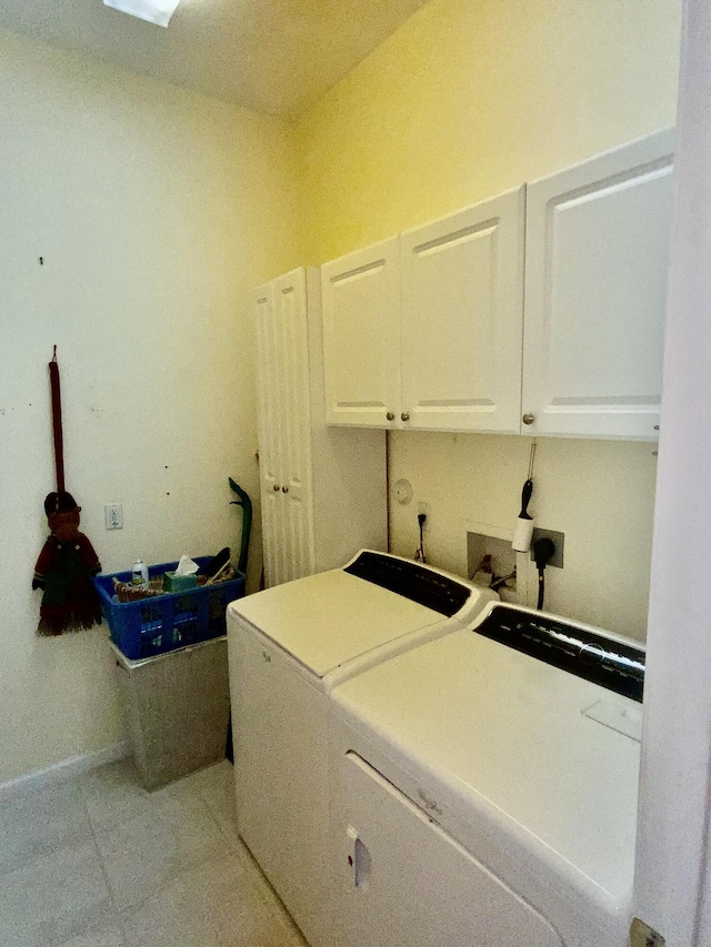 laundry area with cabinets, light tile patterned flooring, and washing machine and clothes dryer