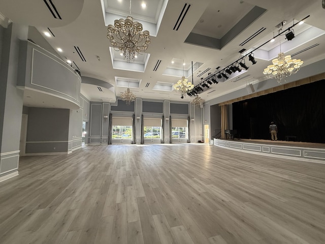 unfurnished living room featuring an inviting chandelier, wood-type flooring, and a high ceiling