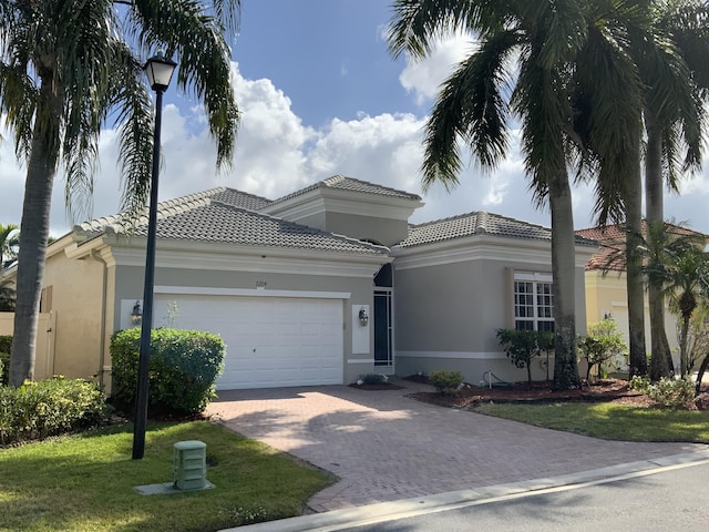 mediterranean / spanish home featuring a garage and a front lawn