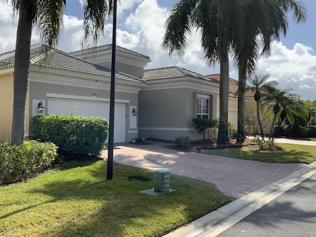 mediterranean / spanish-style home with a garage and a front yard