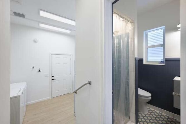 bathroom with hardwood / wood-style flooring and toilet