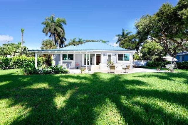 back of house featuring a patio area and a lawn