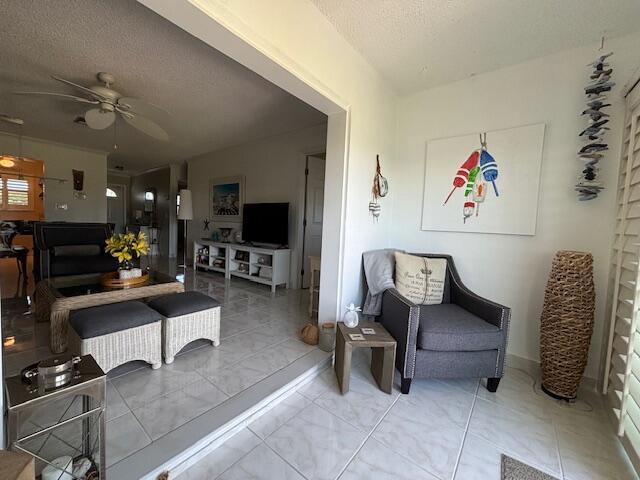 sitting room featuring ceiling fan and a textured ceiling