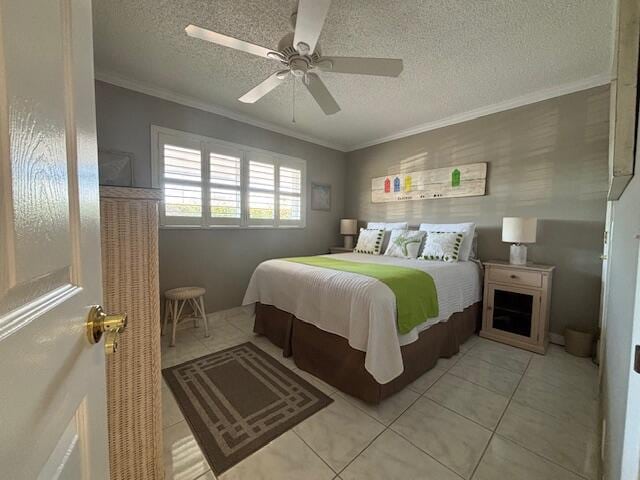 tiled bedroom featuring ceiling fan, ornamental molding, and a textured ceiling