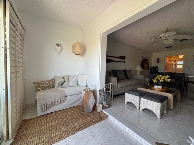 living room with ceiling fan and a textured ceiling